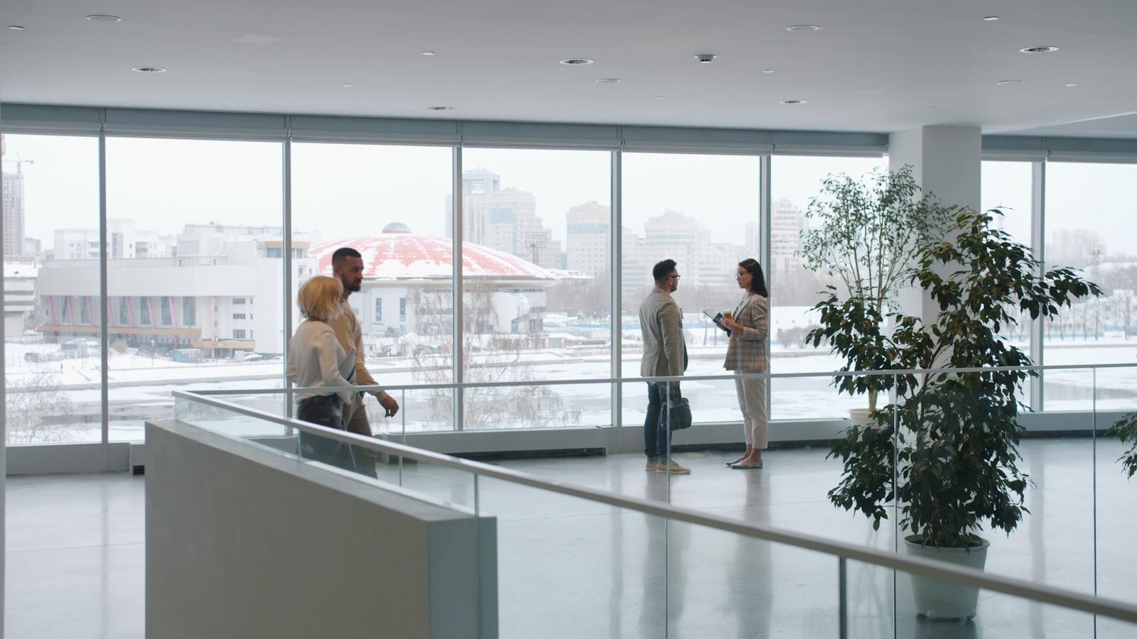 Modern office reception with floor-to-ceiling windows overlooking a city skyline at sunset