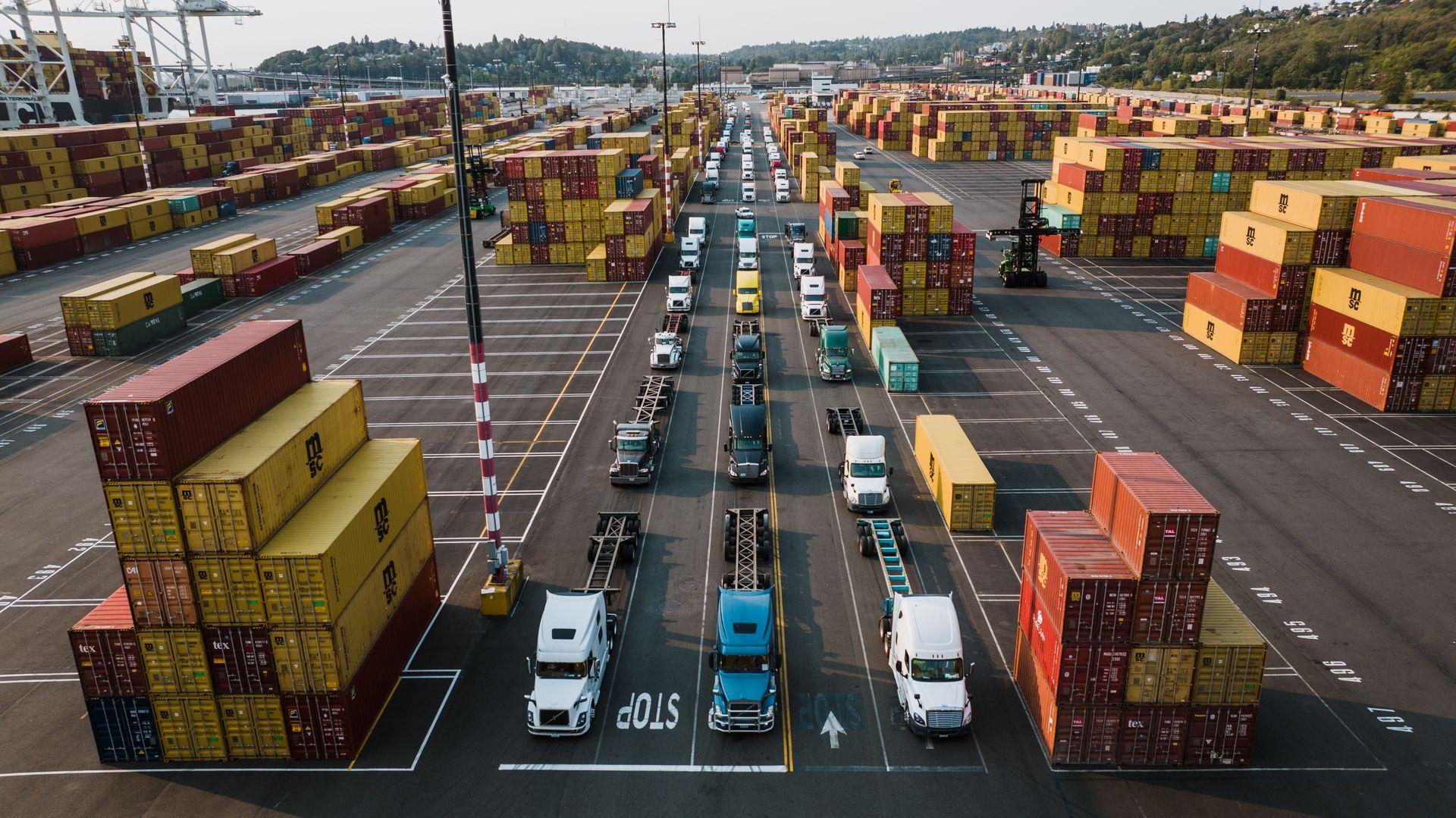 Shipping containers and trucks at a logistics port yard