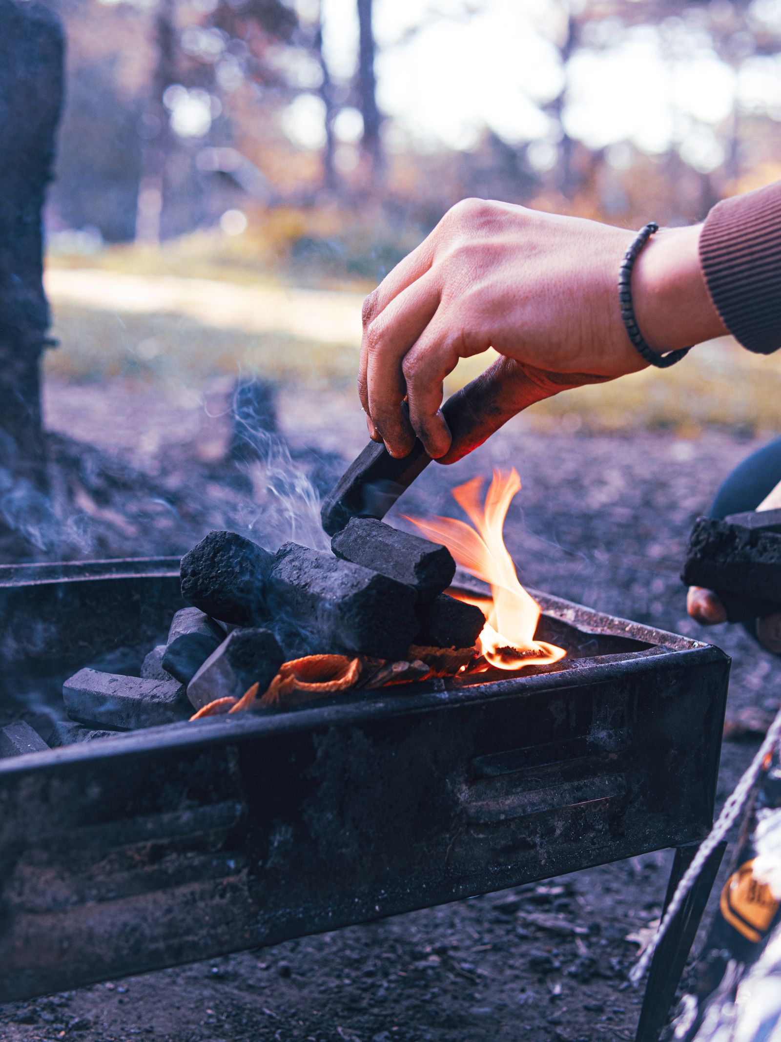 Hands holding eco-friendly charcoal briquettes beside a rustic wooden crate