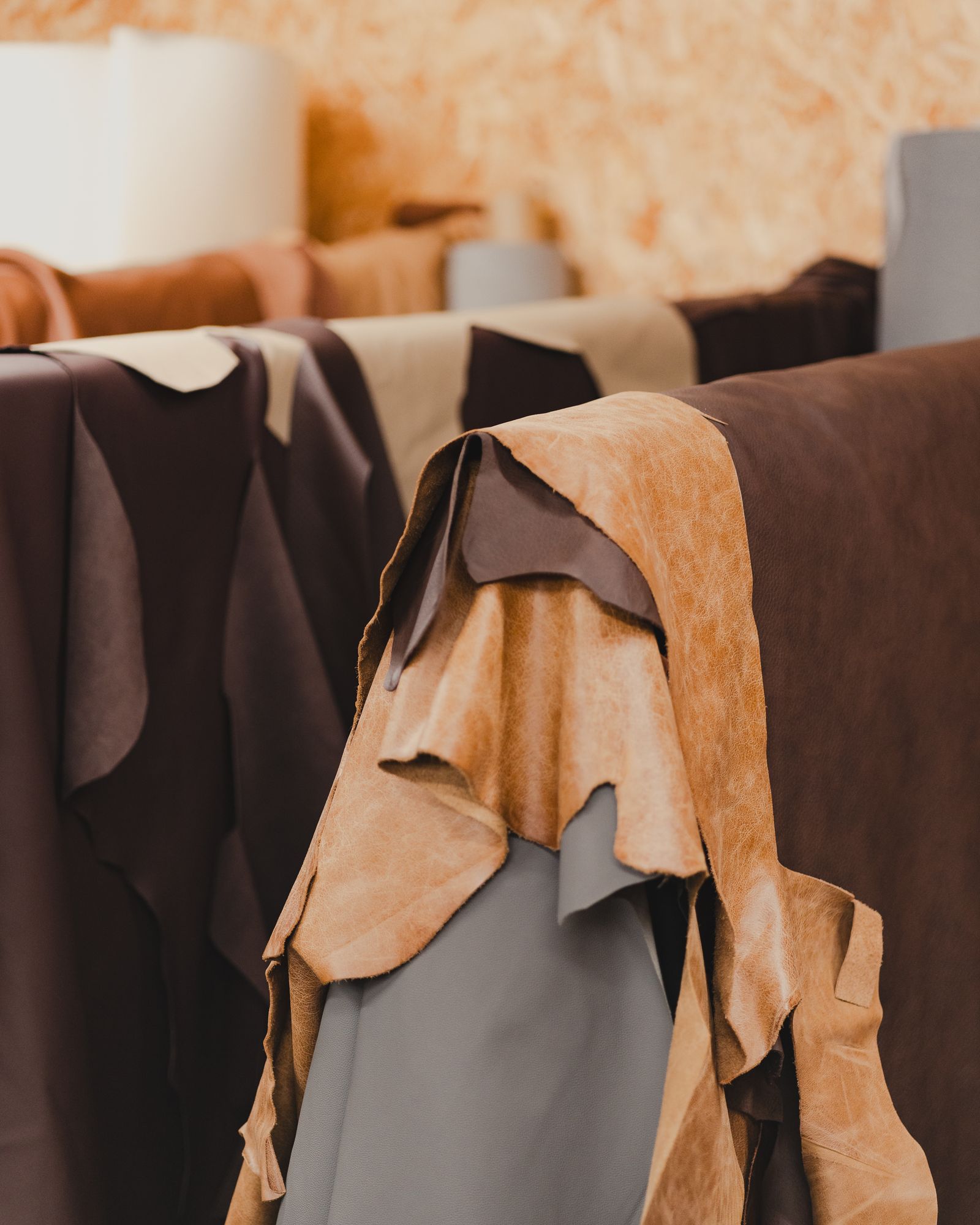 Neatly stacked cured animal hides in a processing warehouse with natural light through a window