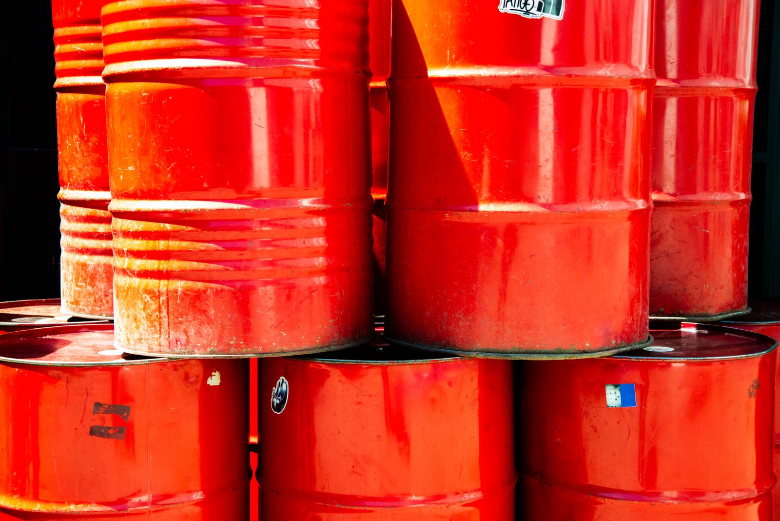 Amber kerosene stored in metal drums under warm golden lighting in an industrial storage yard